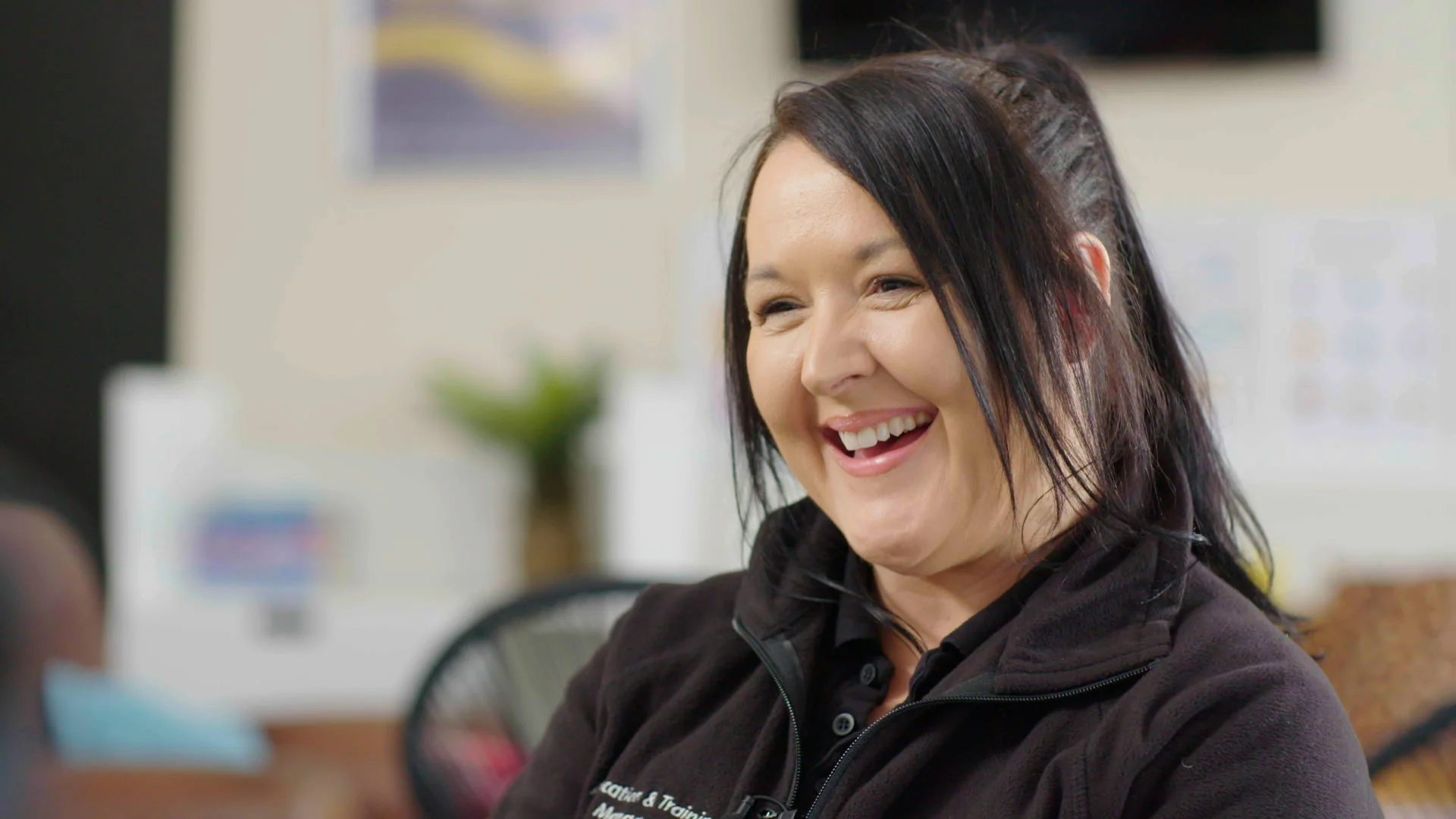 Mastering Camera Setups and Framing: Turps Film Tips 4 A Woman Is Sat, Laughing Whilst Looking To The Left Of Frame.