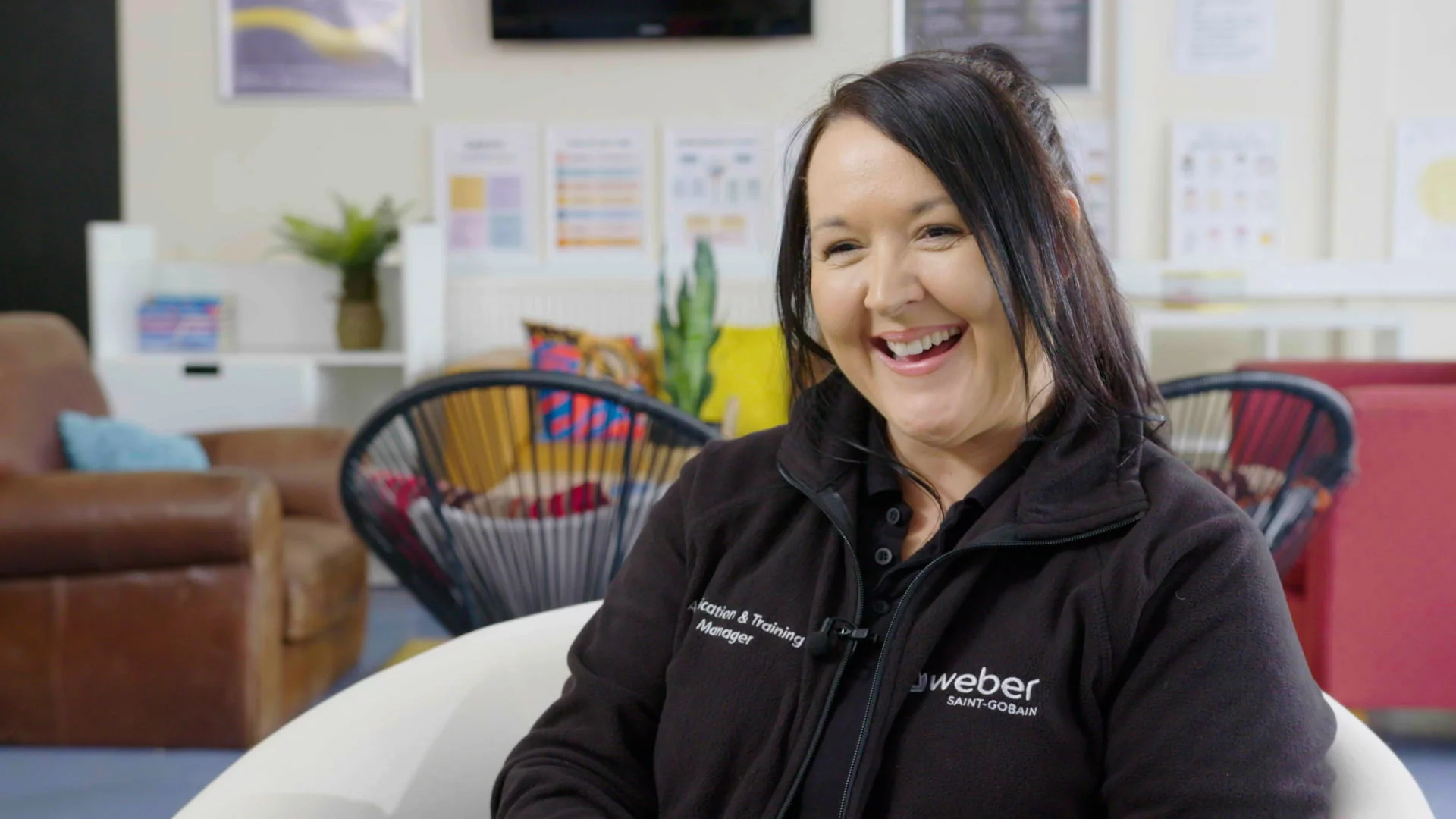 Mastering Camera Setups and Framing: Turps Film Tips 3 A Mid Shot Of A Woman Being Interviewed. She Is Sat In A Chair And Looking Off Camera Whilst Smiling.