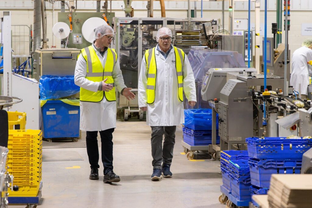Two Ringtons staff in hi-vis walking through the factory